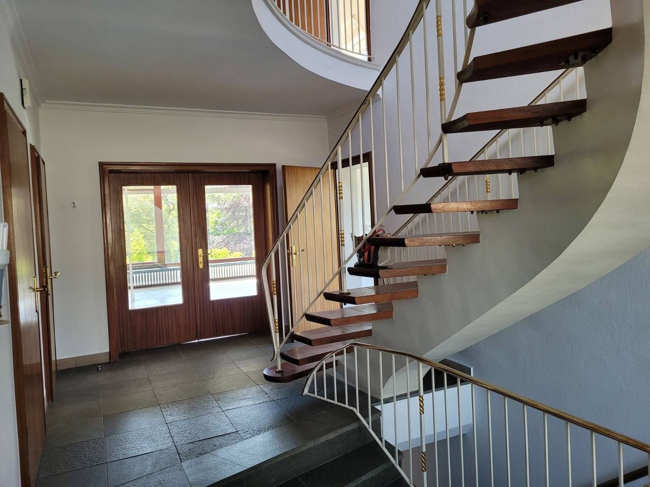 Flur mit geschwungener Holztreppe